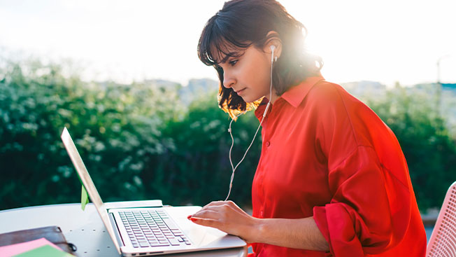 A woman studying on a laptop with IELTS Ready: Premium