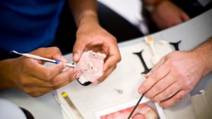 A dentist creating a denture A dentist or orthodontist at work.