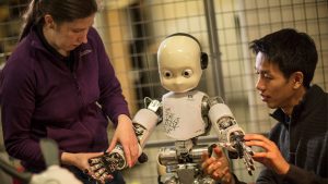 Two people work with a robot Two people are working with a robot